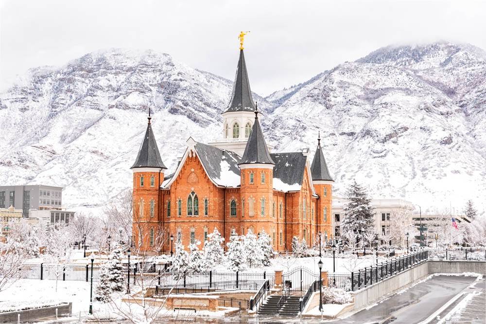Provo City Center Temple standing against a landscape of snowy mountains.