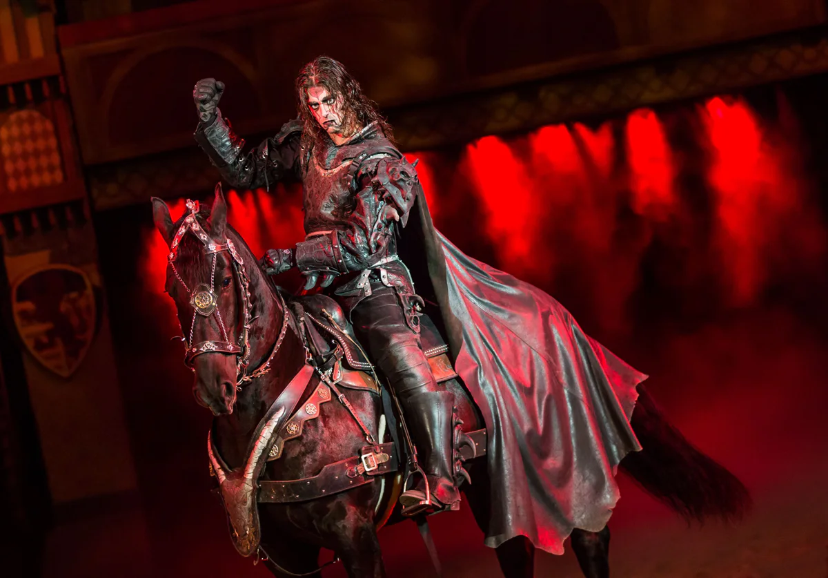 Knights riding horses through the Tournament of Kings arena at Excalibur
