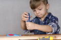 Little boy tightening a screw. 