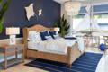 Navy bedroom with seagrass bed and striped navy rug