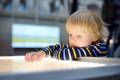 Toddler focusing on a sensory light table activity, exploring textures and visual stimulation.