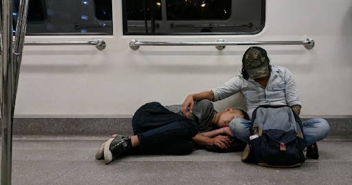 A child asleep while lying on the lap of a foreign worker in the MRT - Photo from Mothership