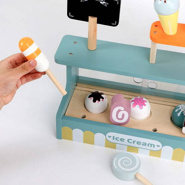 Hand taking an ice cream out of its designated spot on the Ice Cream Shop toy for children.