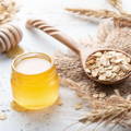 Oats in Wooden spoon and honey in a jar