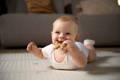 Baby boy biting a wooden rattle toy.