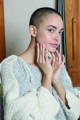 woman touching her face after applying a skin serum
