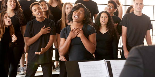 Choral Tracks PLUS Membership - High School choral students practicing their singing with their teacher.