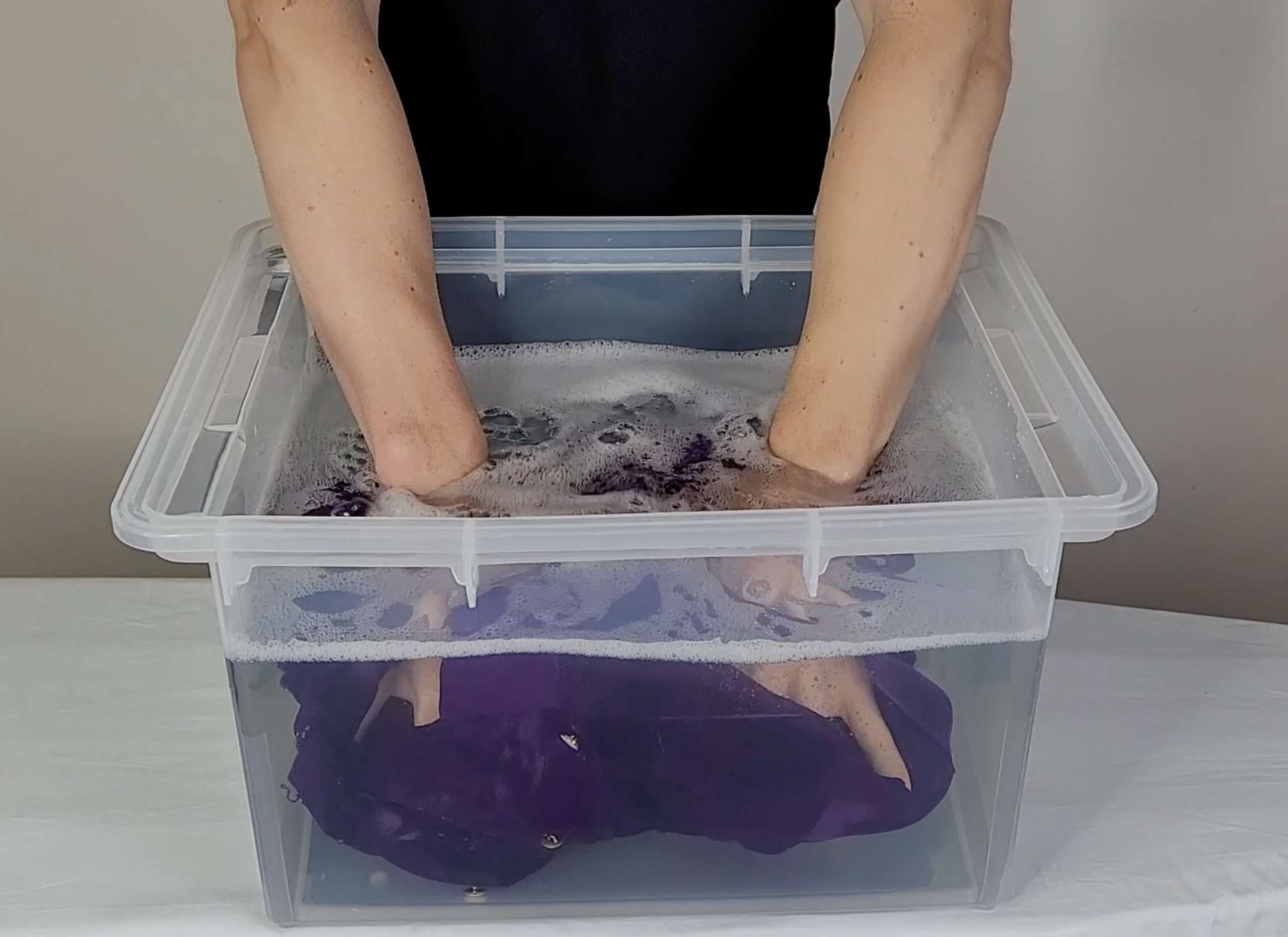 photo of a main submerging a silk shirt in water