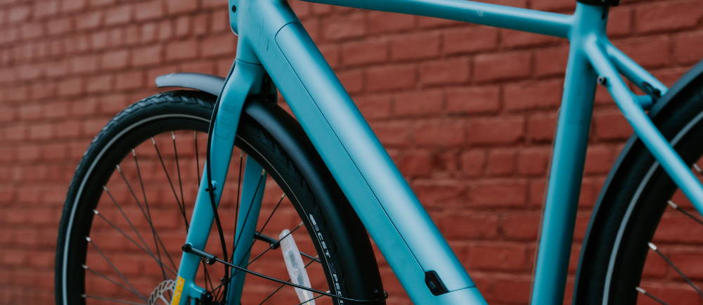 a teal Tenways electric city bike