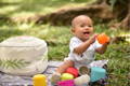 Baby holding a cup and smiling.