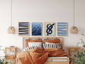 Coastal art prints above a bed