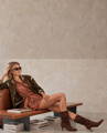 Model in an olive bomber jacket, paisley dress and brown suede boots - The Fall Collection