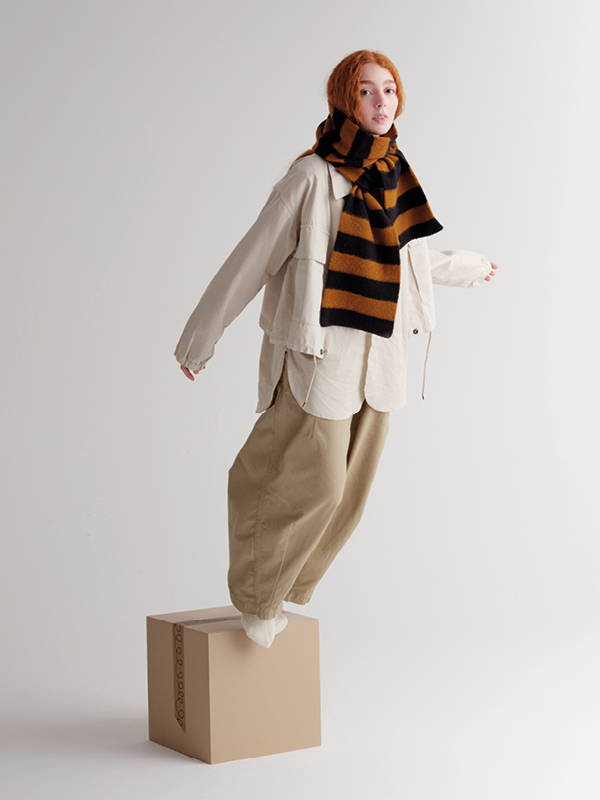 model wears Brushed Stripe Scarf Black & Cumin
