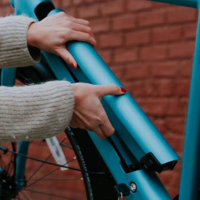 Close up of someone removing an Aventon e-bike battery