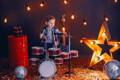 Little boy playing small children's drums in a cute disco setup. 