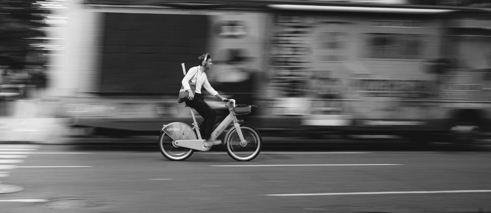 a man riding a citi bike electric bike in NYC (black and white)