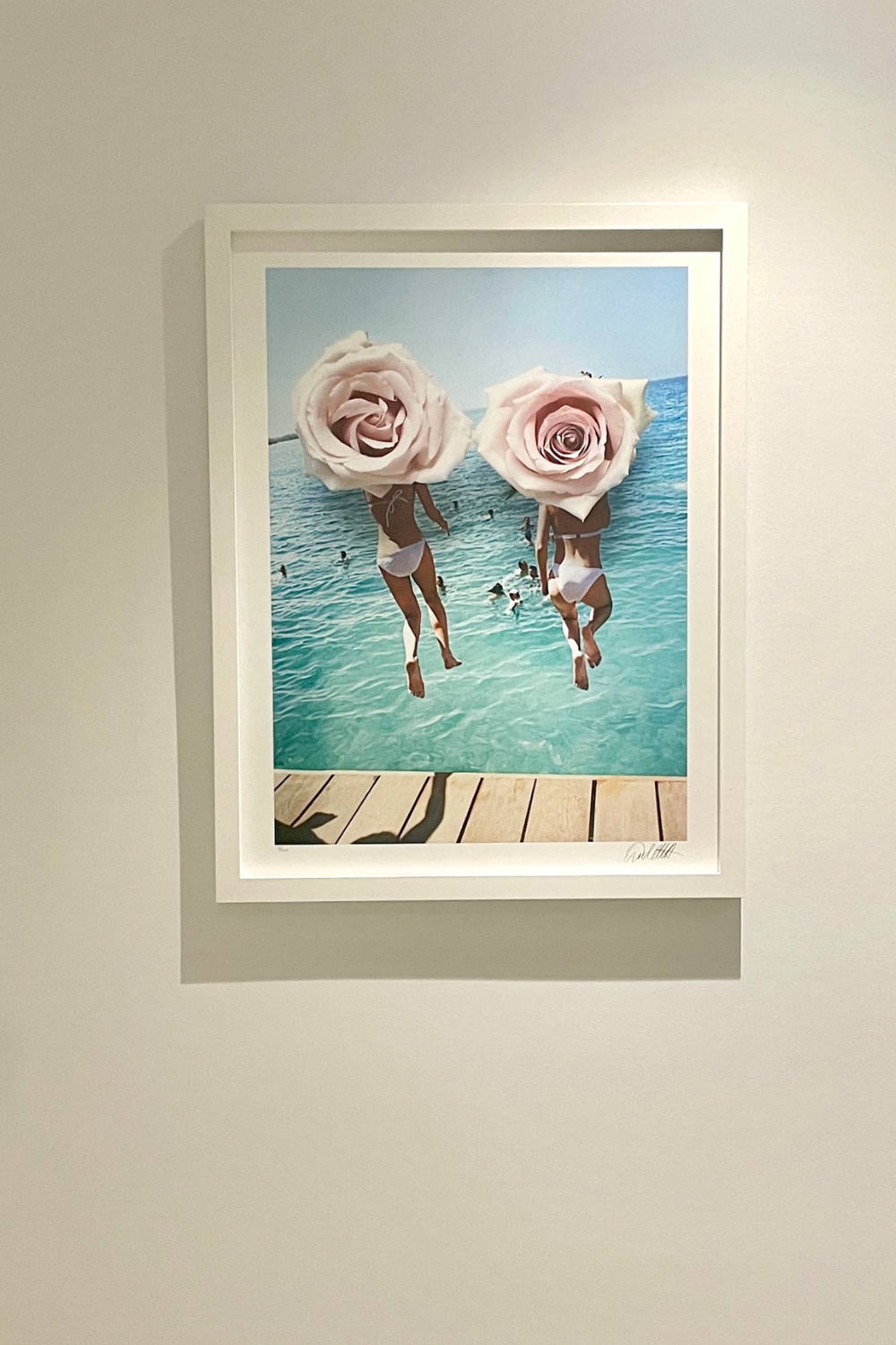 'Catch Me If You Can' by Dina Broadhurst - A photographic print of two girls jumping off a pier, with pink roses over the top of the image creating a collage-effect.