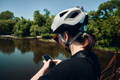 Femme cycliste qui verifie son telephone devant un lac
