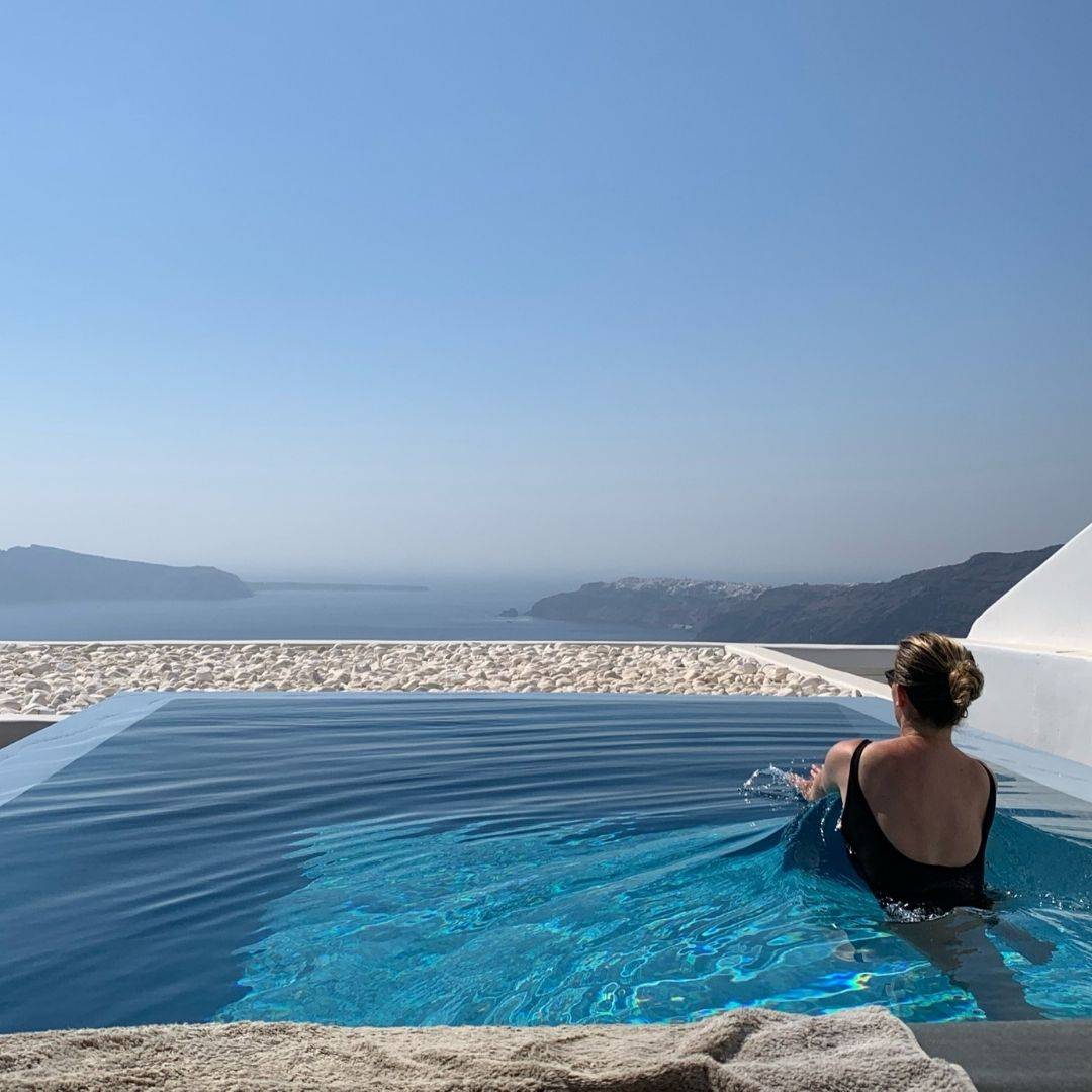 Cavotagoo infinity pool overlooking Santorini caldera at sunset