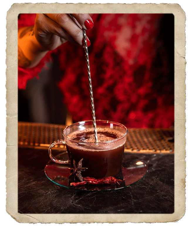 Bartender stirring hot chocolate drink with long metal stirrer