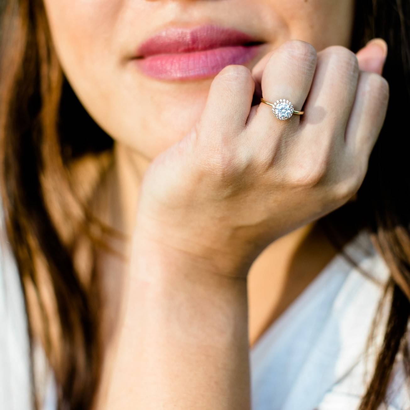 A woman's hand wearing lab-grown diamond engagement rings created by Sceona