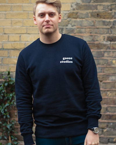 Man wearing navy blue organic cotton sweatshirt from sustainable brand Goose Studios