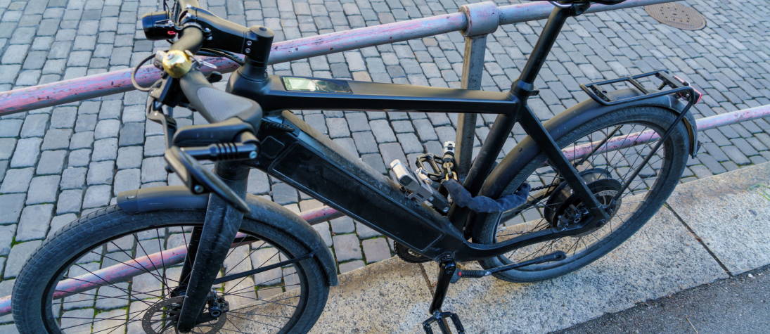 Black Electric Bike Chain Locked to Railing