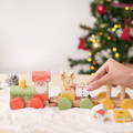Woman's hand interacting with colorful wooden Christmas figurines of the Montessori Xmas Brain Train set.