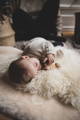 A sleeping baby on a long sheepskin rug on a shorn sheepskin rug for comparison
