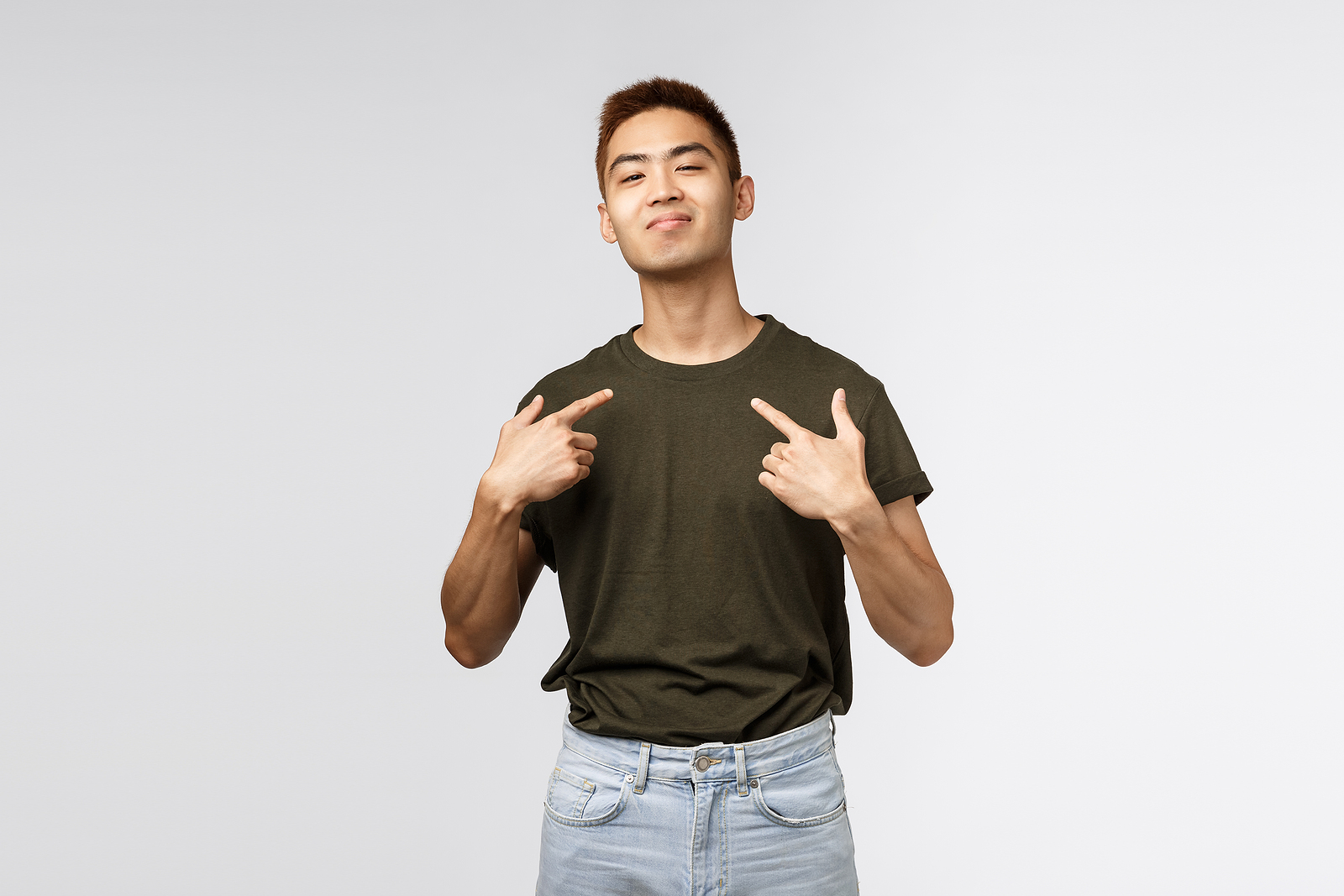 Hip and attractive Asian guy with red dark red hair, smirking and pointing with both hands towards him.