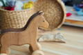 Wooden horse toy with wheels.