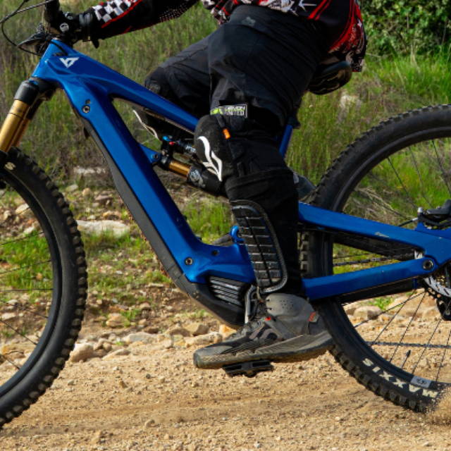 a man riding a blue full suspension electric mountain bike