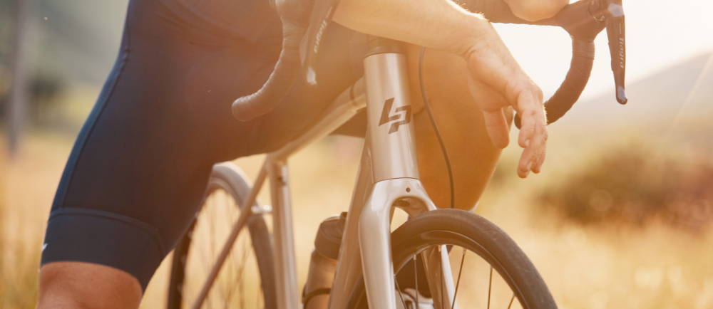 a man riding a La Pierre electric road bike at sunset