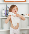 A kid trying to put on a shirt by themselves