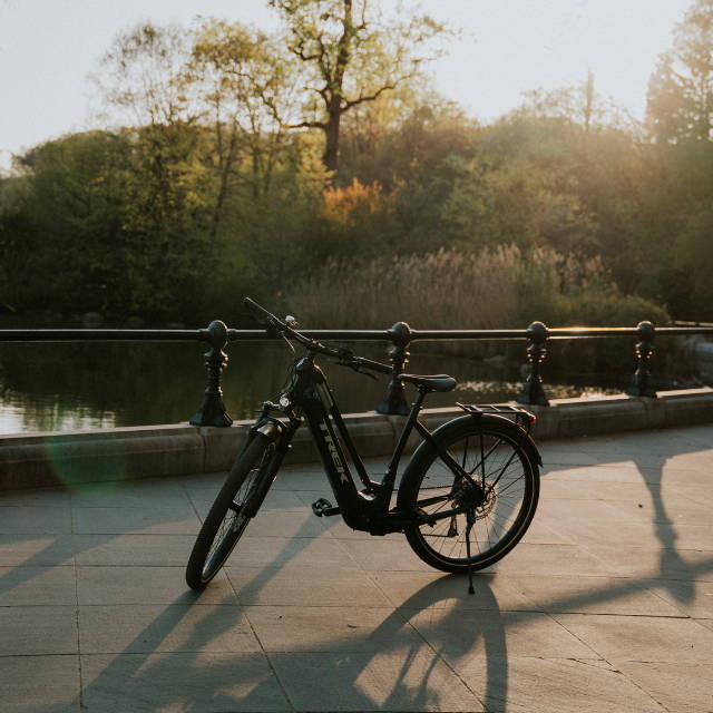 a trek allant electric city bike on a bike path next to a lake