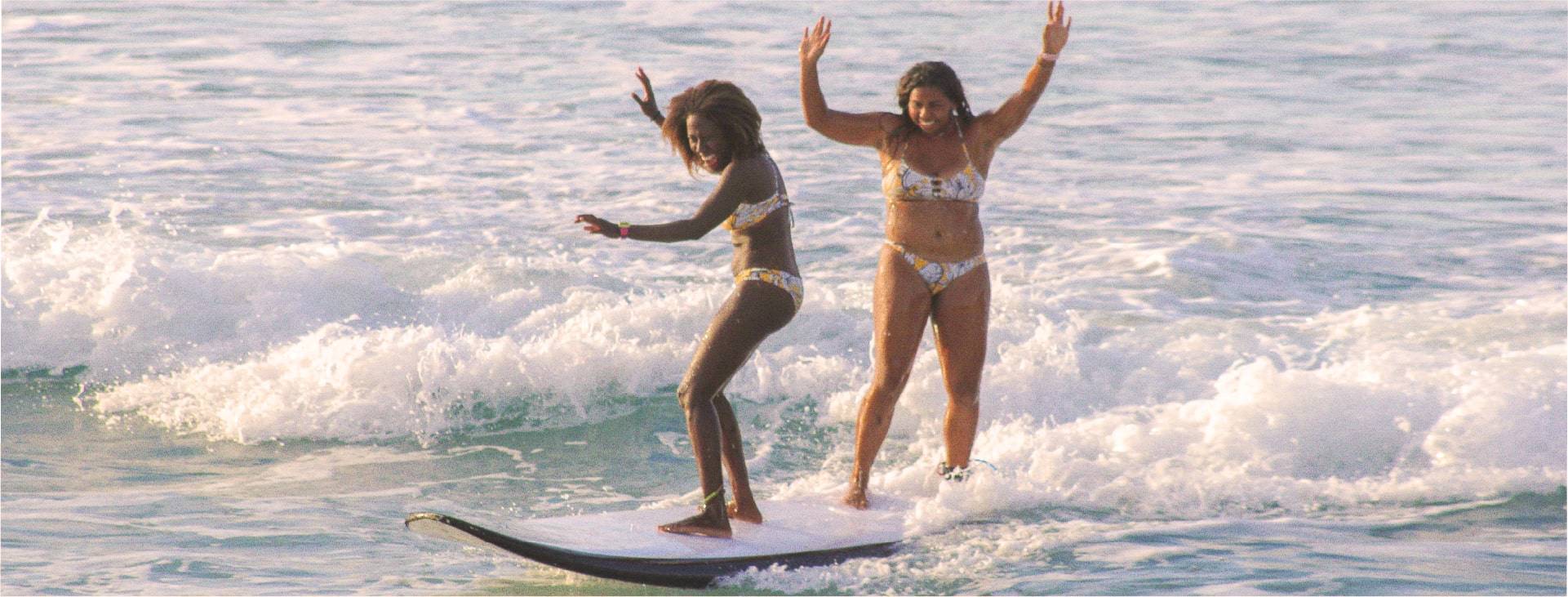 Chrissana Wilmot & Tiara B. Jones surfing together at Tortola beach