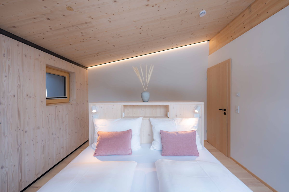 Schlafbereich mit Dachschräge und Doppelbett im Apartment Hochsitz.