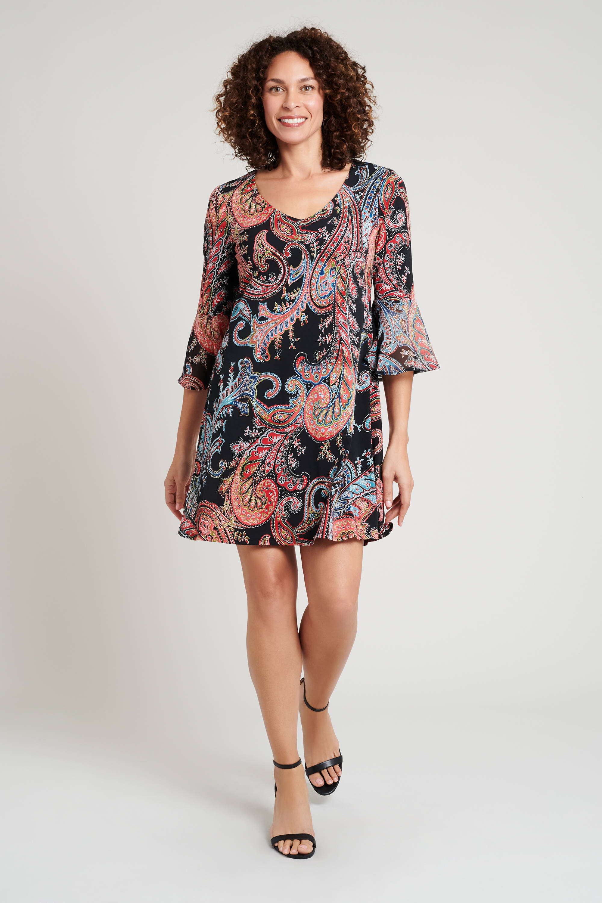 woman posing in half sleeve paisley print short connected apparel dress with matching printed chiffon sleeve accents