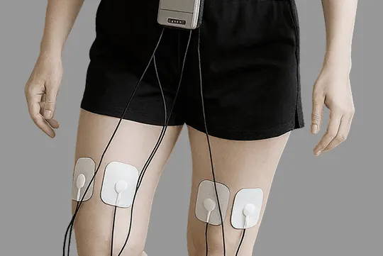 両足にケーブルが接続された有線TENS装置で動きを制限する