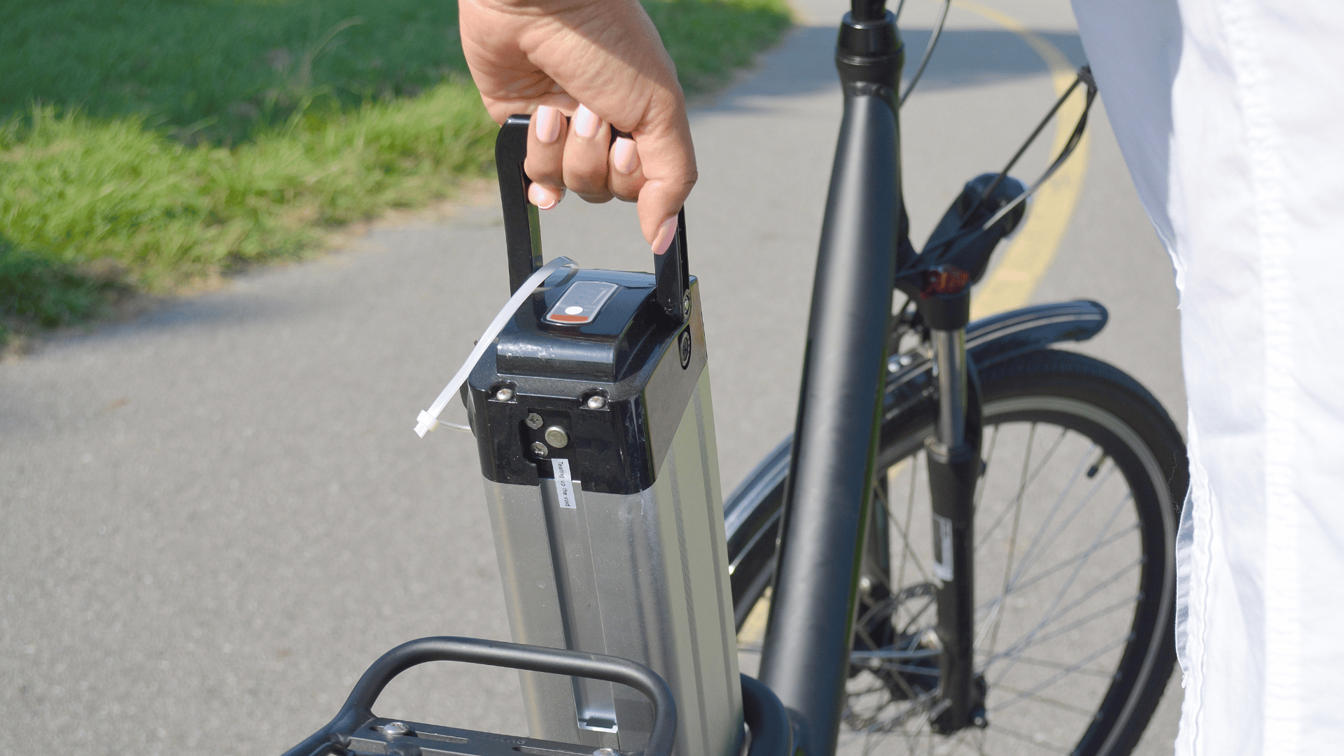 vrouw neemt accu uit elektrische fiets