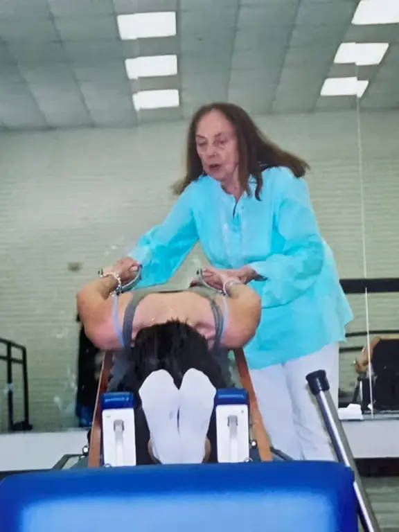 Photo of Romana teaching Dana on a reformer