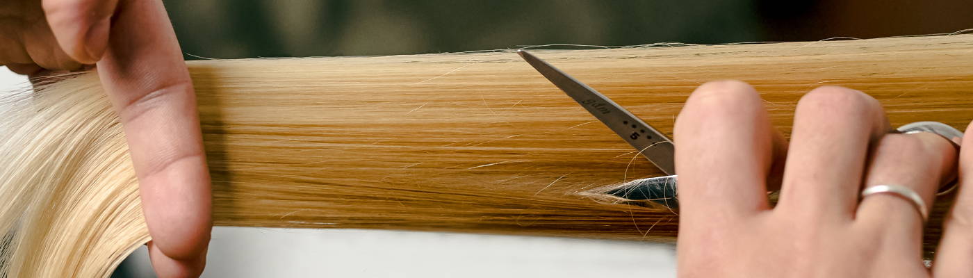 Close-up of sleek blonde hair being cut by a Davines stylist