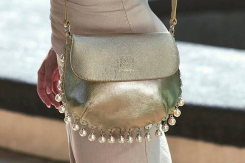 Close up view of the CHARMAINE gold shoulder bag with hanging pearl charms.