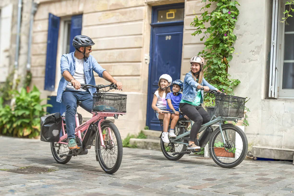 Une famille se balade à Paris avec leur vélo électrique Jean Fourche vendu acheté chez ShiftBikes