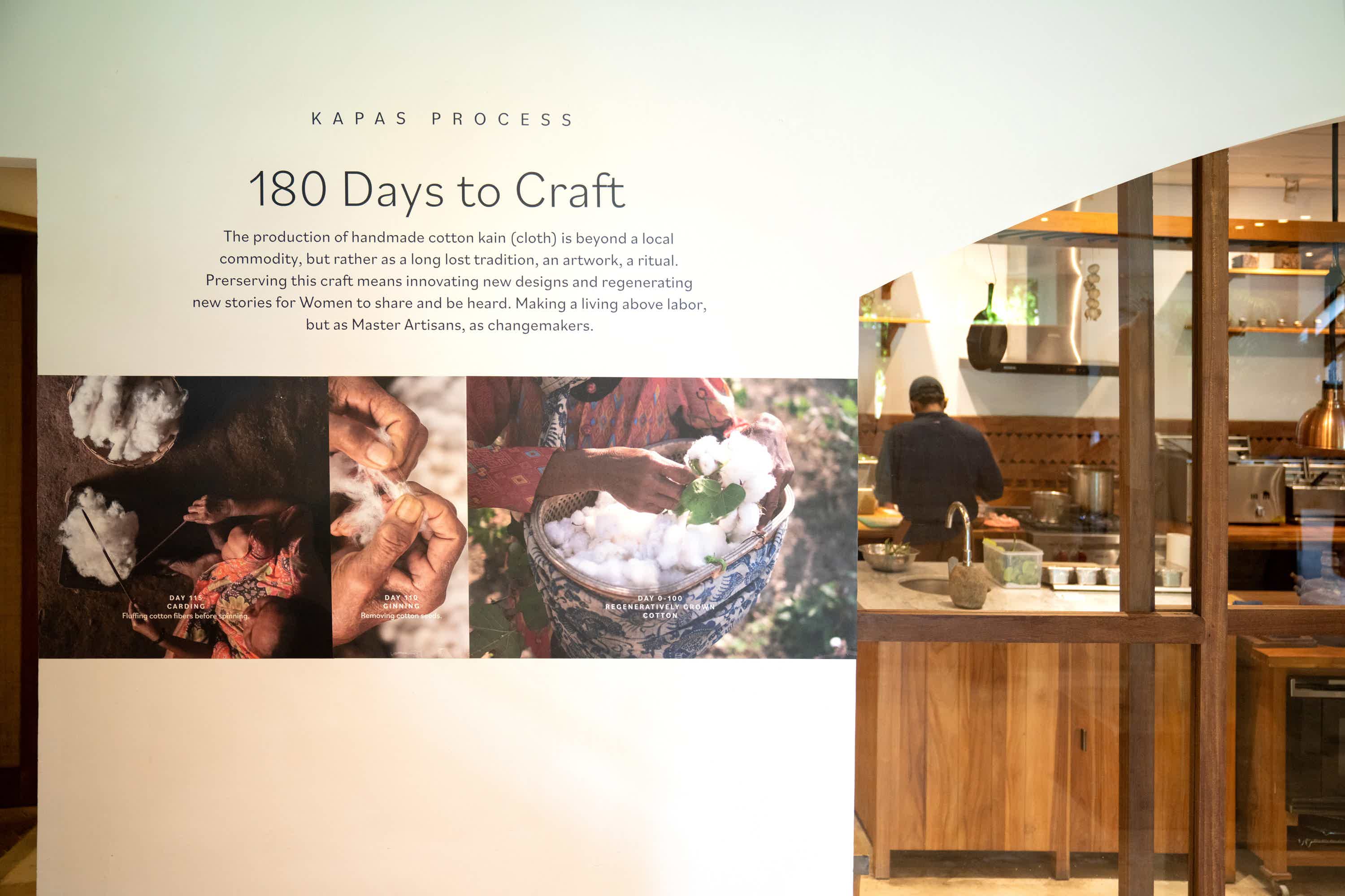 KAPAS Installation by SukkhaCitta in John Hardy Boutique & Gallery at Seminyak. Photographs of Indonesian indigenous cotton pickers are plastered on the wall. Text reads: KAPAS PROCESS. 180 Days to Craft. The production of handmade cotton kain (cloth) is beyond a local commodity, but rather as a long lost tradition, an artwork, a ritual. Preserving this craft means innovating new designs and regenerating new stories for Women to share and be heard. Making a living above labor, but as Master Artisans, as changemakers.