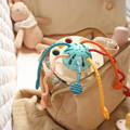 A Silicone Pulling toy for babies placed in a beautiful beige bag.