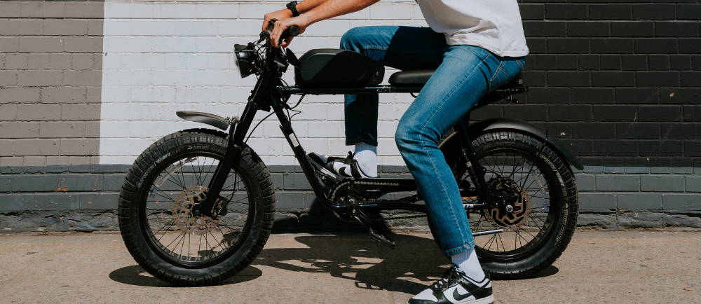 a man in jeans sitting on a mini motor electric bike