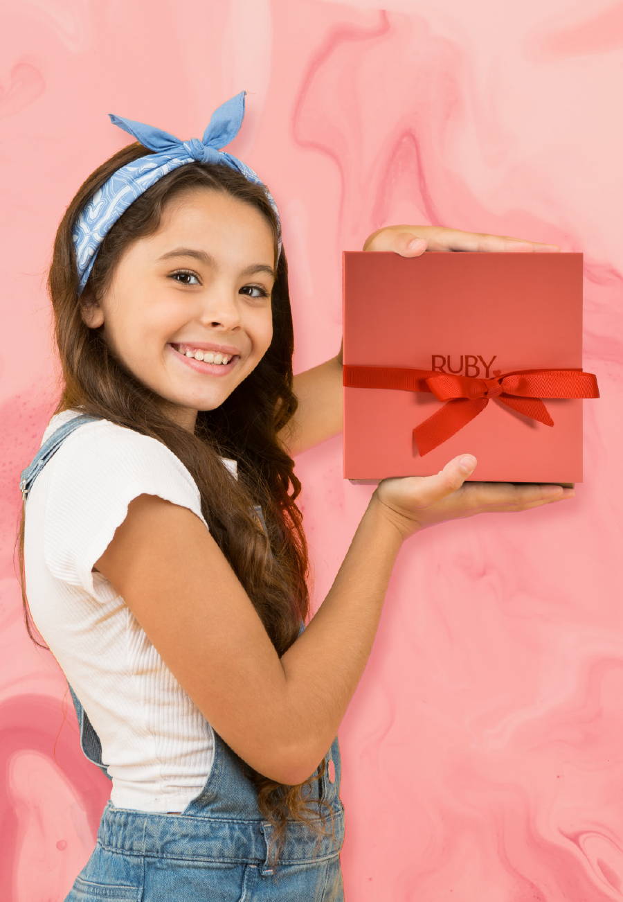 A girl holding a red Ruby Love gift set box