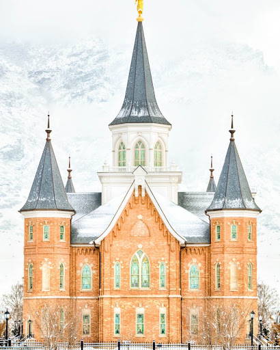 Provo City Center Temple standing against snow-covered mountains.