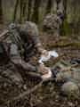 EOlife clinical device being used by military in the woods to help treat a soldier laying on the ground.